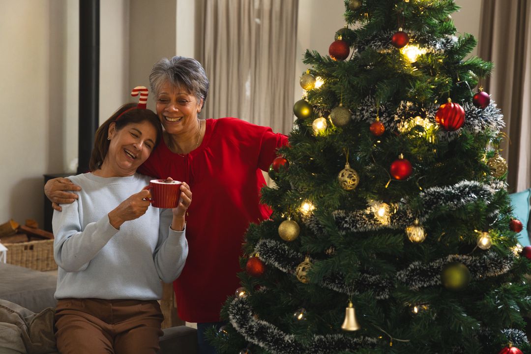 Mother and Daughter Enjoying Holiday by Decorated Christmas Tree