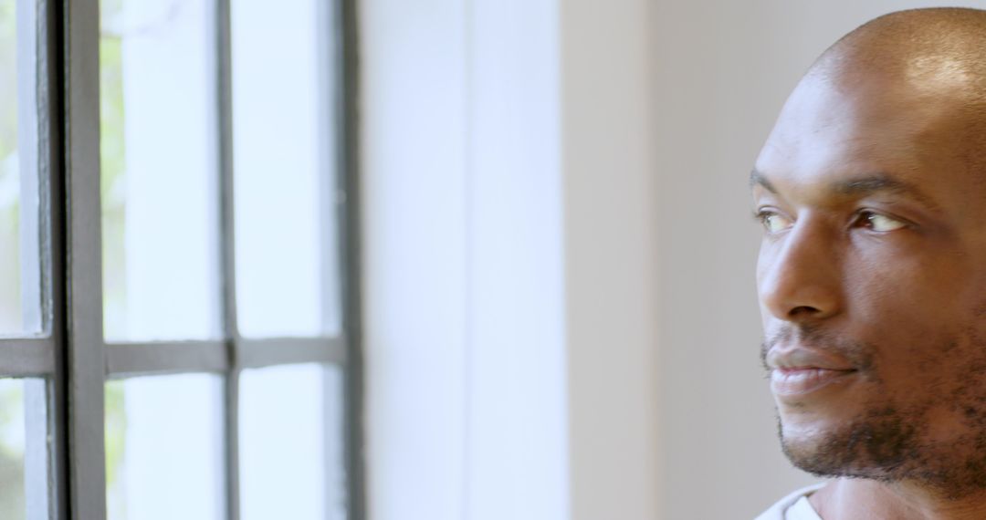 Reflective Middle-Aged Man Standing by Bright Window