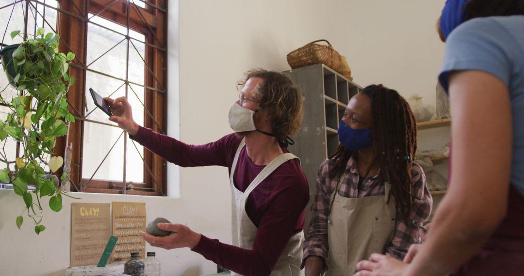 Artists Collaborating in Ceramics Studio Wearing Masks - Free Images, Stock Photos and Pictures on Pikwizard.com