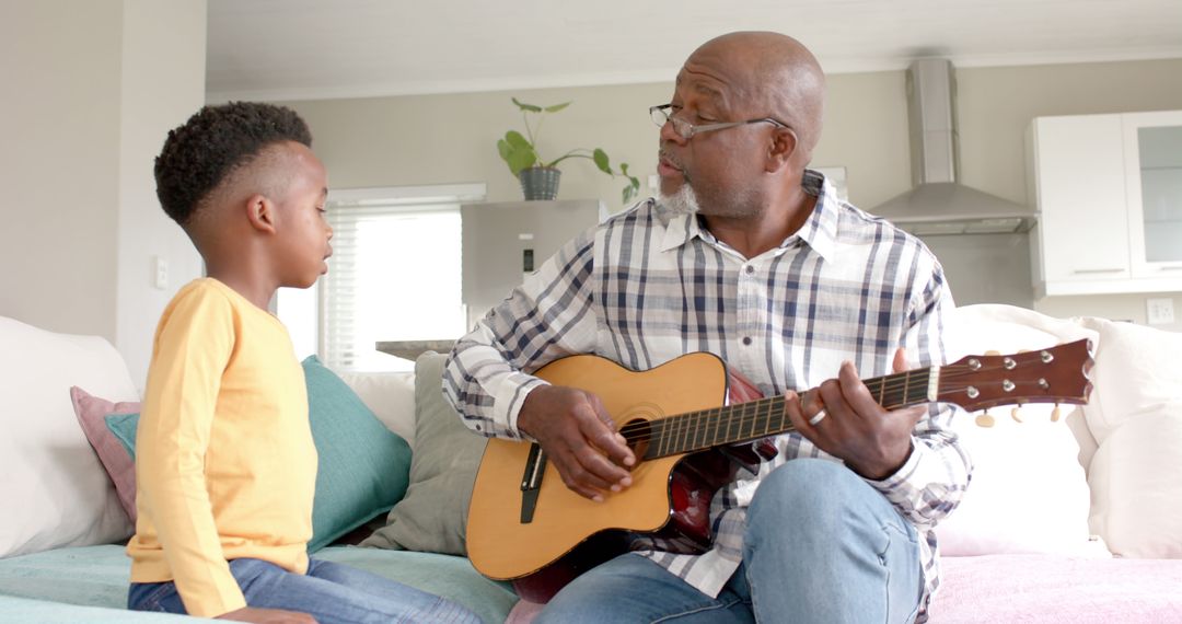 Grandfather Teaching Grandson to Play Guitar at Home - Free Images, Stock Photos and Pictures on Pikwizard.com