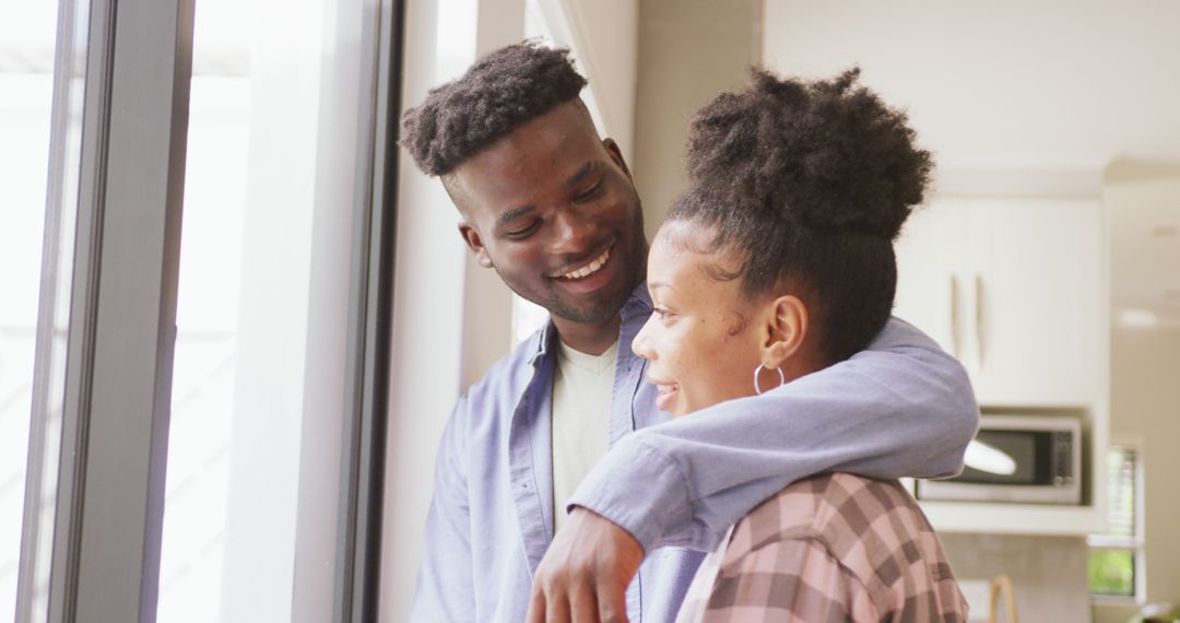 Image of happy african american couple standing at window and embracing - Free Images, Stock Photos and Pictures on Pikwizard.com