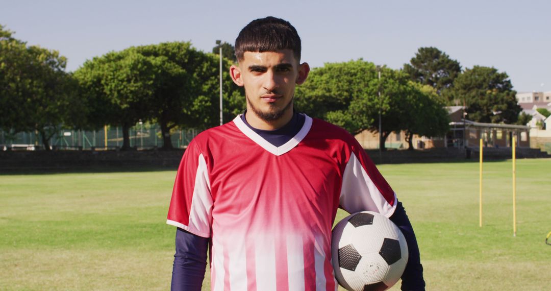 Confident Young Male Soccer Player Holding Soccer Ball on Field - Free Images, Stock Photos and Pictures on Pikwizard.com