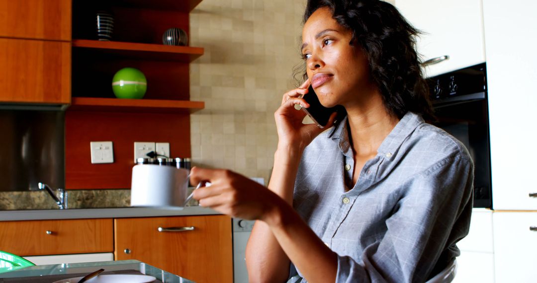 Woman Enjoying Coffee While Talking on Phone in Modern Kitchen - Free Images, Stock Photos and Pictures on Pikwizard.com