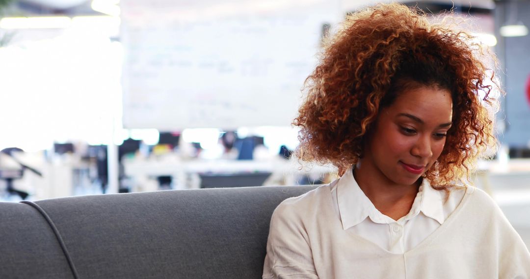 Smiling Woman Reviewing Notes in Modern Office Lounge