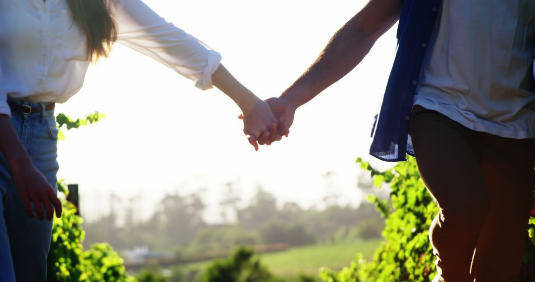 Romantic Young Couple Holding Hands at Sunset Outdoors