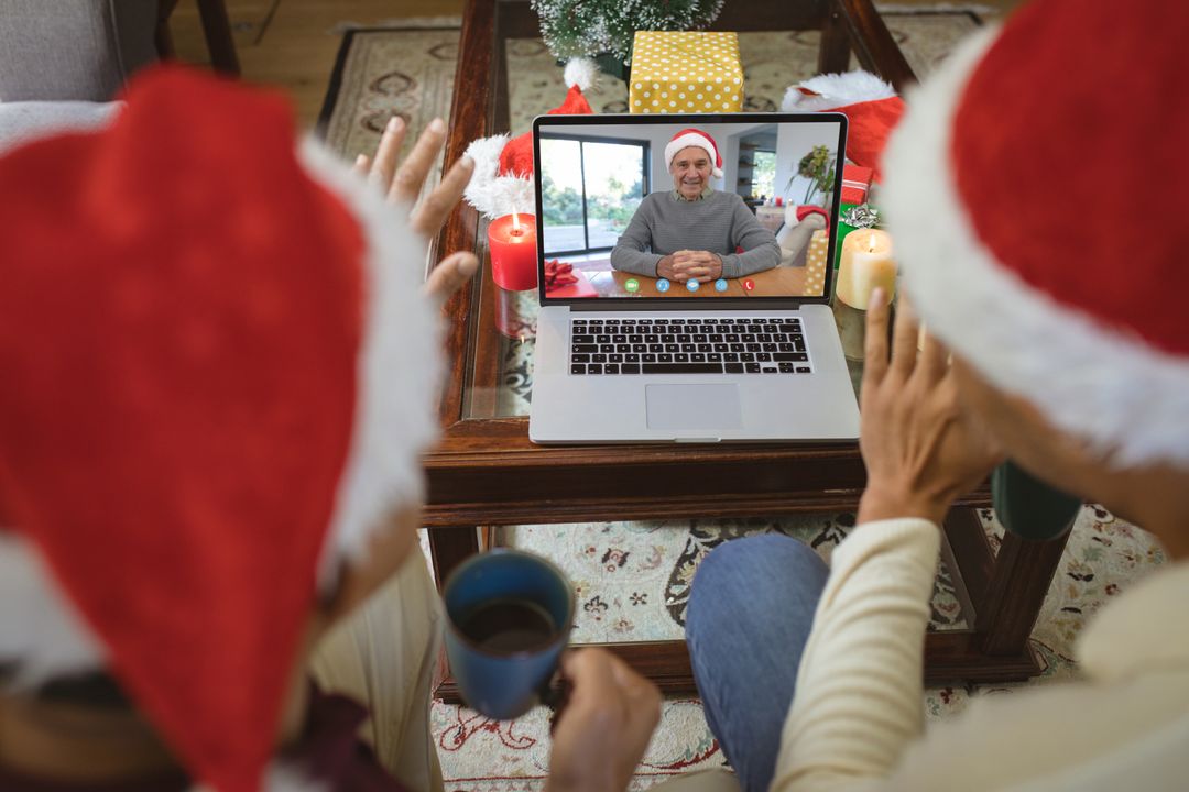 Diverse Couple Wearing Santa Hats Video Calling During Christmas Celebration - Free Images, Stock Photos and Pictures on Pikwizard.com