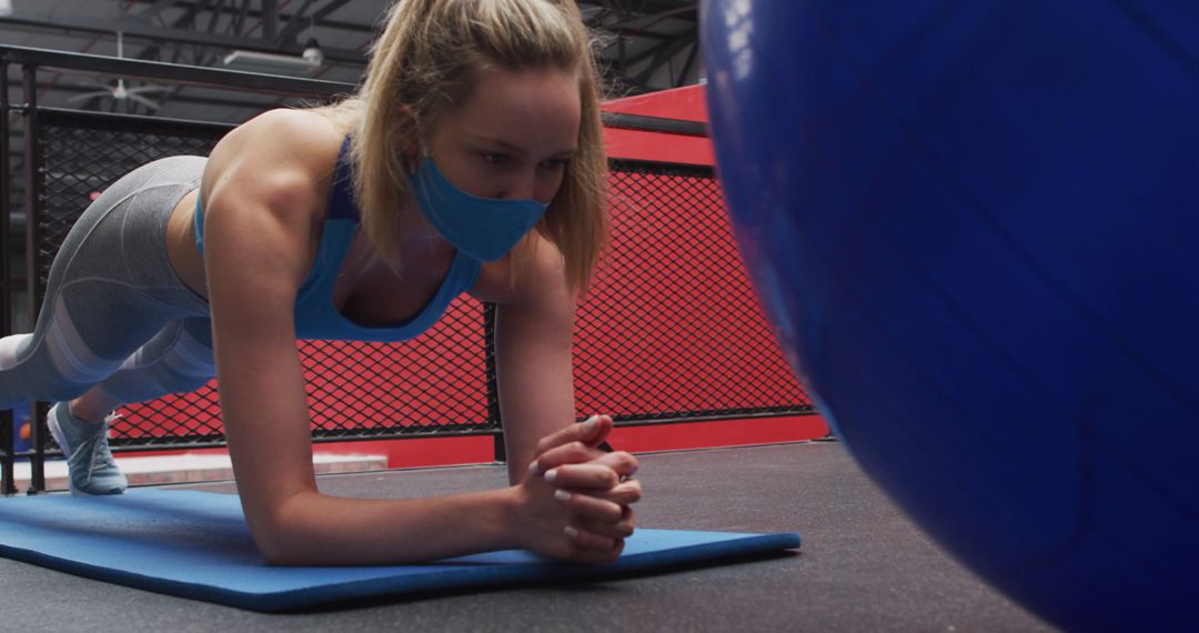 Young Woman Exercising on Mat with Protective Mask in Gym - Free Images, Stock Photos and Pictures on Pikwizard.com