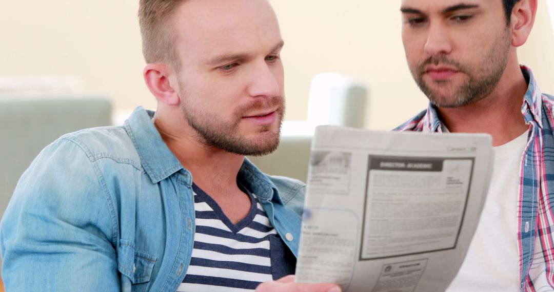 Two Men Reading Newspaper Together in Living Room - Free Images, Stock Photos and Pictures on Pikwizard.com