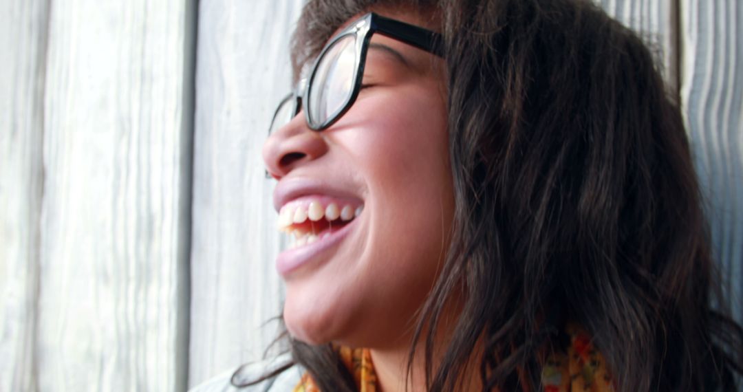 Joyful Woman Laughing Wearing Black Glasses Outdoors - Free Images, Stock Photos and Pictures on Pikwizard.com