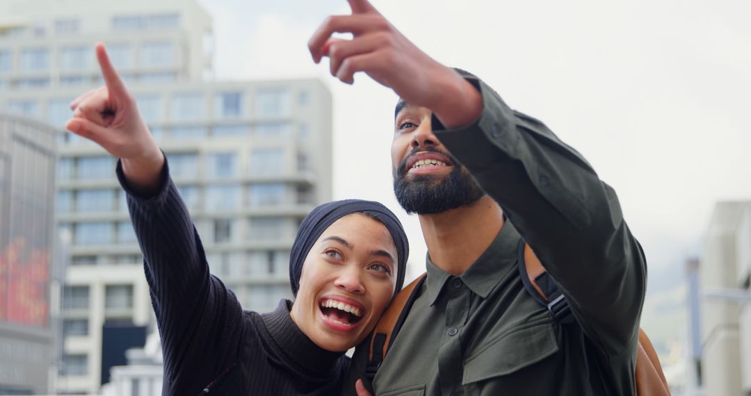 Joyful Couple Pointing at Urban Landmark in City