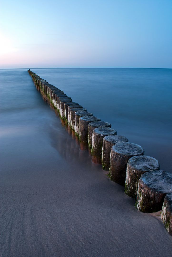 Long Pier Extends into Calm Sea at Sunset - Free Images, Stock Photos and Pictures on Pikwizard.com