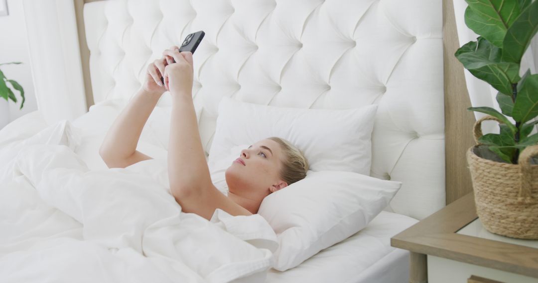 Woman Relaxing in Bed Using Smartphone in Bedroom - Free Images, Stock Photos and Pictures on Pikwizard.com