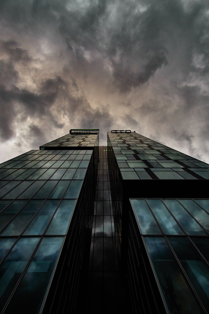 Modern skyscraper with dramatic stormy sky - Free Images, Stock Photos and Pictures on Pikwizard.com