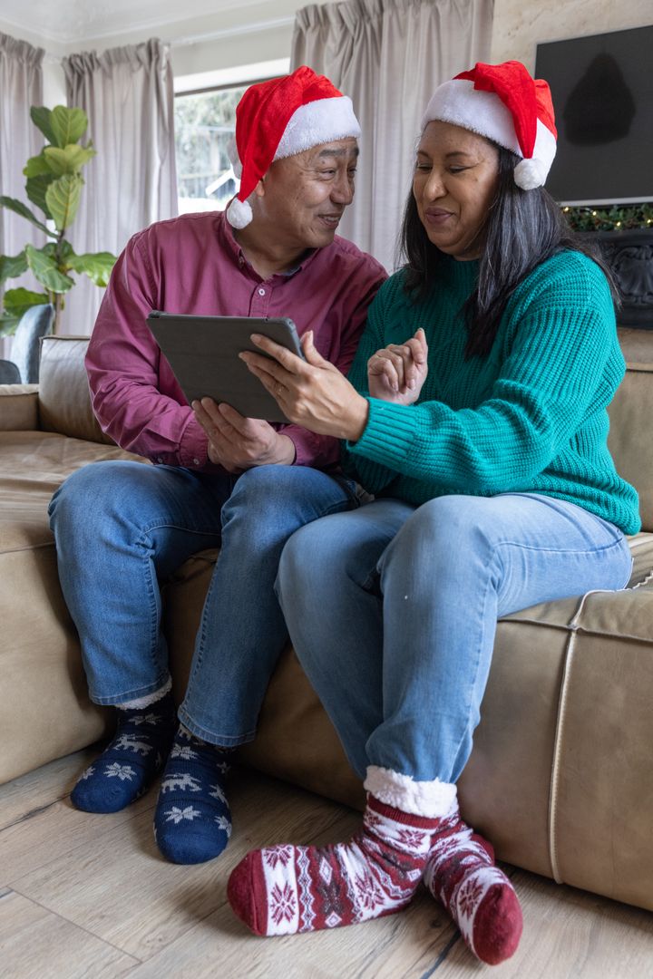 Diverse Couple Enjoying Festive Season Together with Tablet