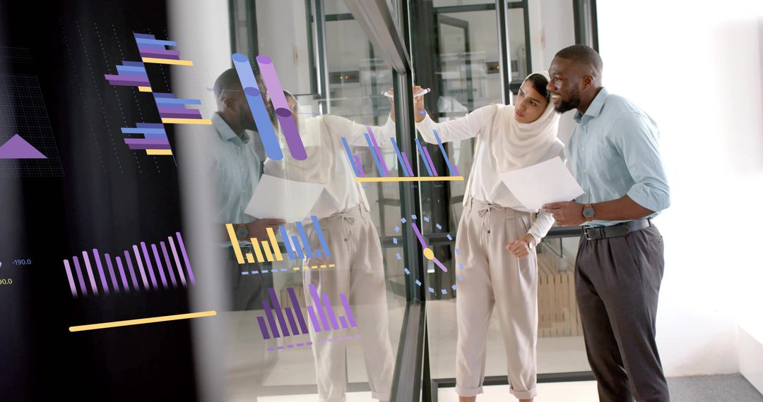 Diverse Business Team Analyzing Charts and Data on Glass Wall