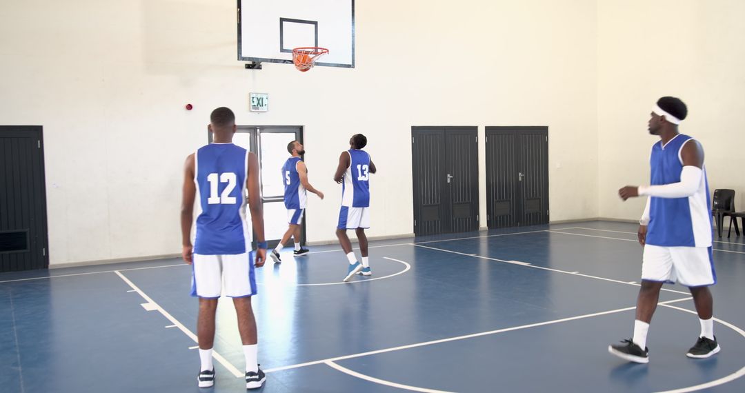 Diverse Basketball Team Practicing in Gym with Blue Jerseys