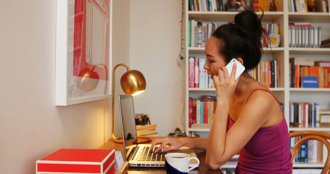 Young Woman Working from Home Office While Talking on Phone - Free Images, Stock Photos and Pictures on Pikwizard.com