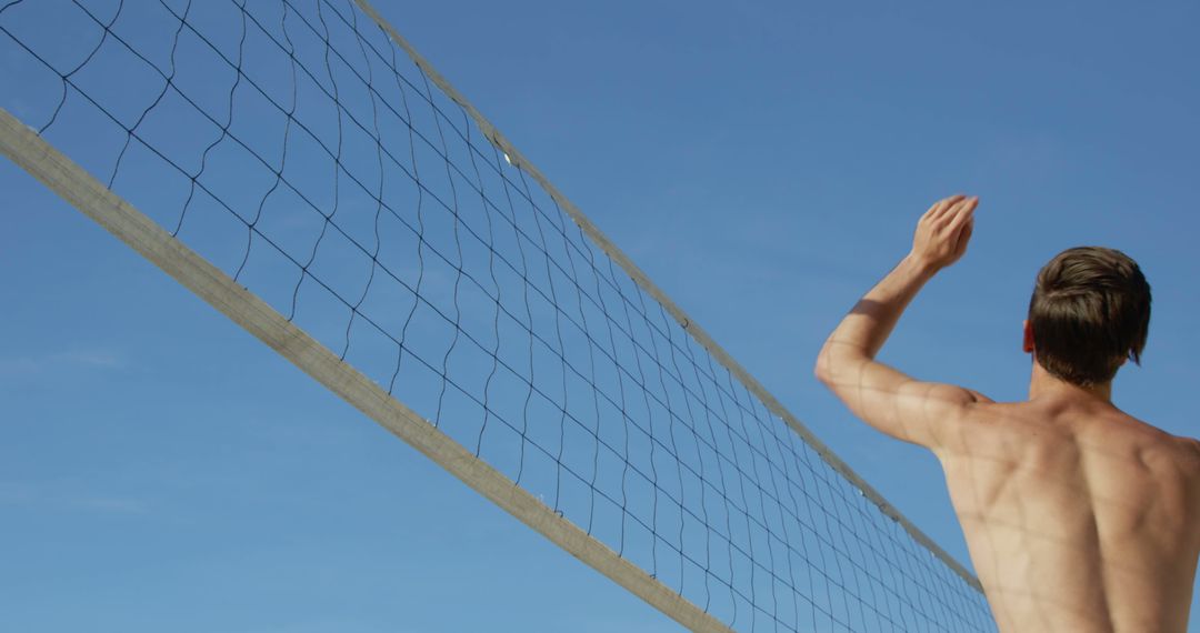 Young Man Playing Beach Volleyball Under Clear Blue Sky - Free Images, Stock Photos and Pictures on Pikwizard.com