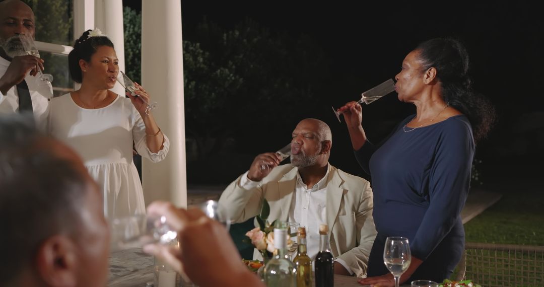 Friends Enjoying Evening Celebration with Drinks in Backyard Gathering