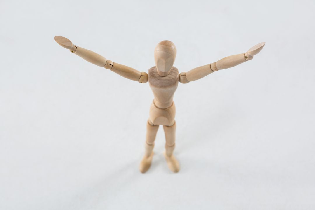 Wooden Figurine with Arms Spread on White Background - Free Images, Stock Photos and Pictures on Pikwizard.com