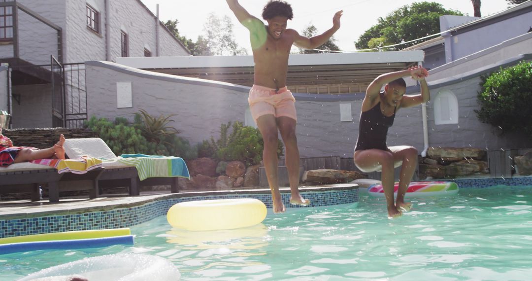 Group of Friends Jumping into Swimming Pool at Party