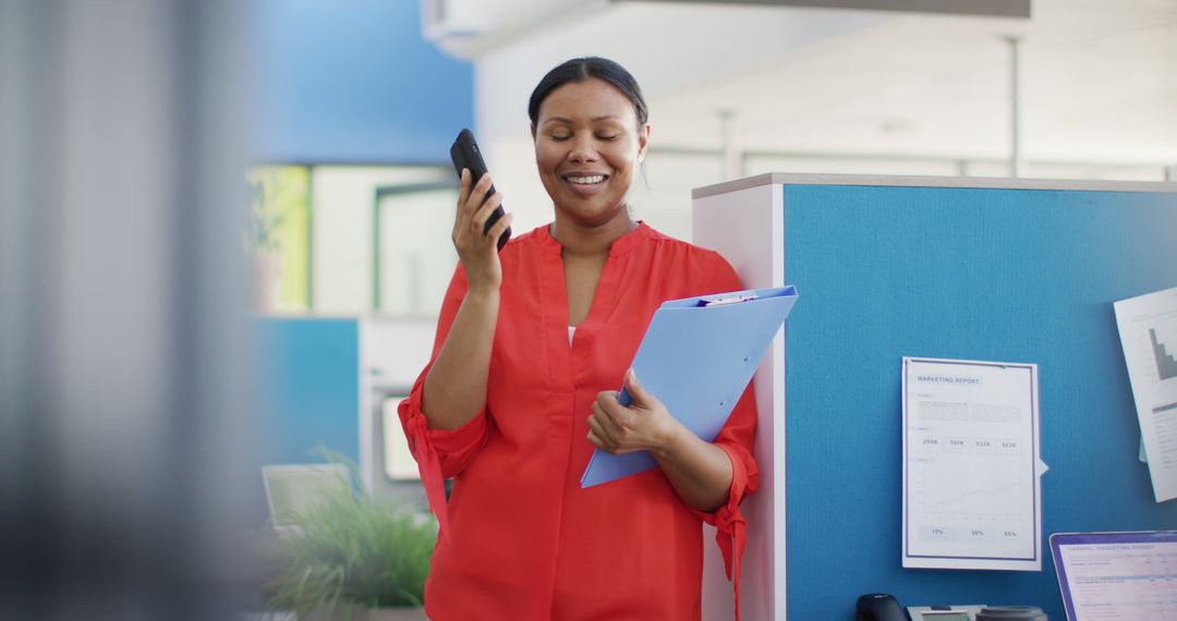 Smiling Woman Talking on Smartphone in Modern Office - Free Images, Stock Photos and Pictures on Pikwizard.com