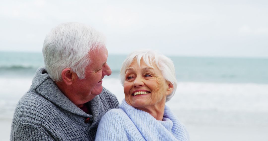 Happy Senior Couple Embracing at the Beach - Free Images, Stock Photos and Pictures on Pikwizard.com