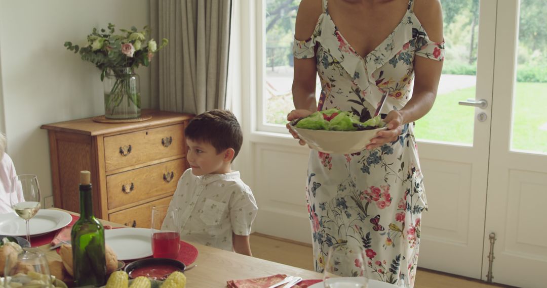 Mother Serving Salad While Young Son Stands Next to Dining Table - Free Images, Stock Photos and Pictures on Pikwizard.com