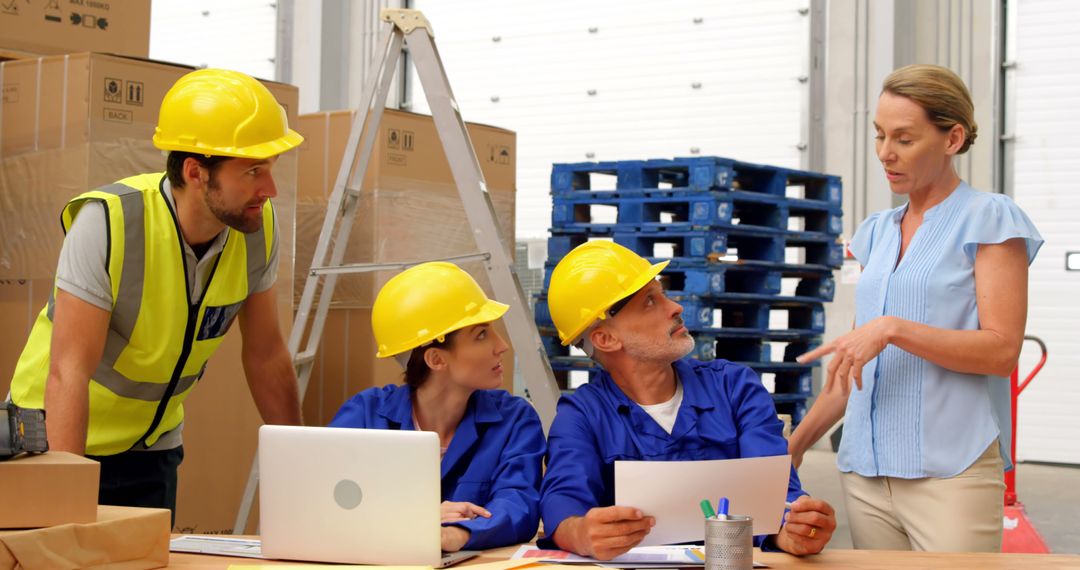 Warehouse Team Discussing Work Plan Around Laptop - Free Images, Stock Photos and Pictures on Pikwizard.com