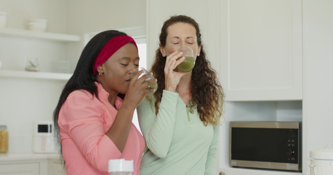 Diverse Women Enjoying Green Juice in Modern Kitchen