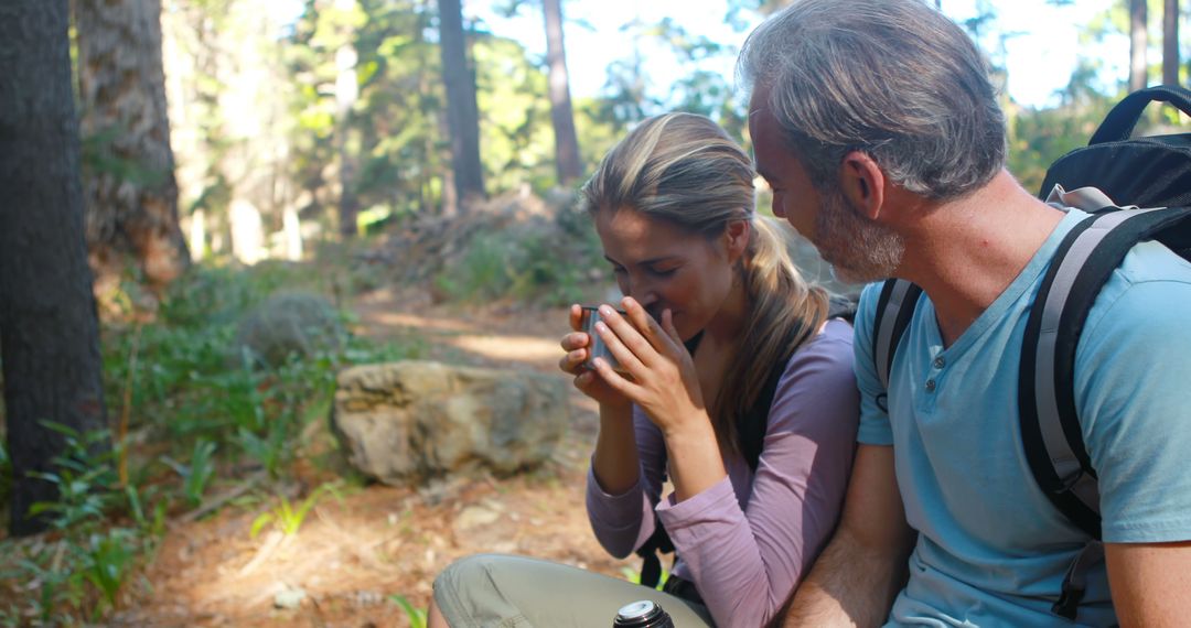 Hiker Couple Enjoying Coffee Break in Lush Forest - Free Images, Stock Photos and Pictures on Pikwizard.com