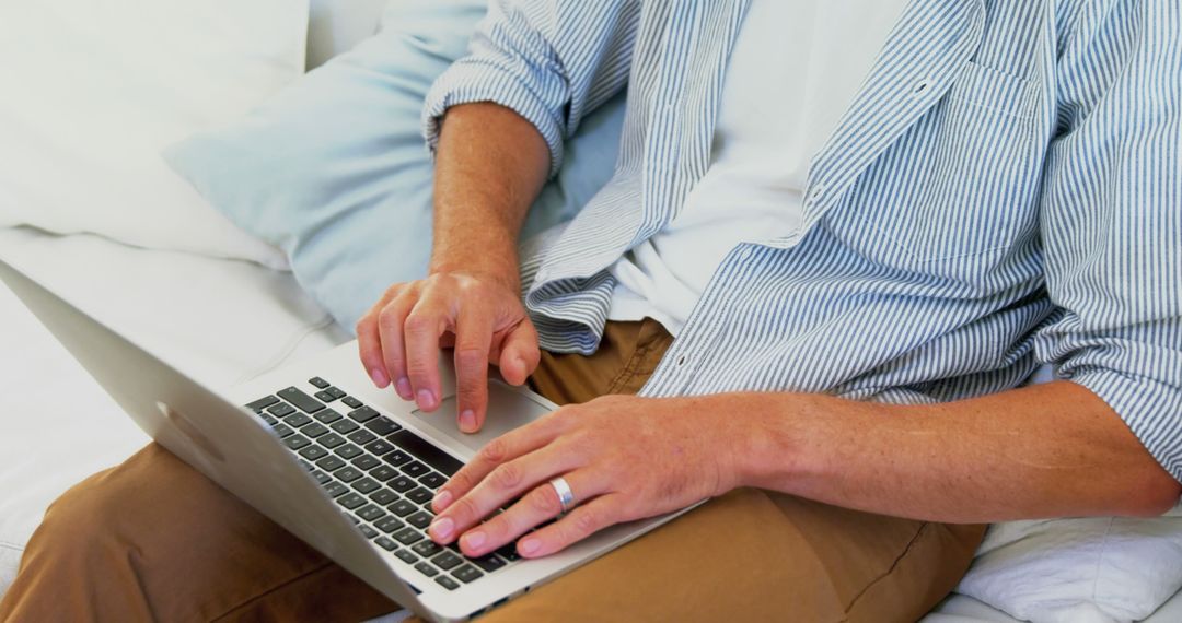 Man Working on Laptop While Sitting on Comfortable Couch - Free Images, Stock Photos and Pictures on Pikwizard.com