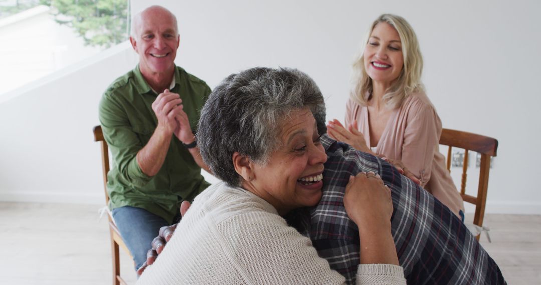 Elderly Friends Laughing and Embracing in Bright Room - Free Images, Stock Photos and Pictures on Pikwizard.com