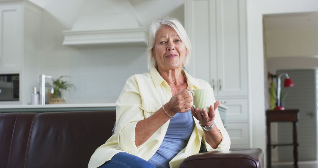 Relaxed Senior Woman Drinking Coffee in Modern Kitchen - Free Images, Stock Photos and Pictures on Pikwizard.com