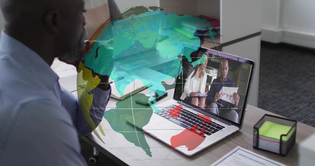 Executive watching virtual meeting on laptop with globe overlay for global collaboration