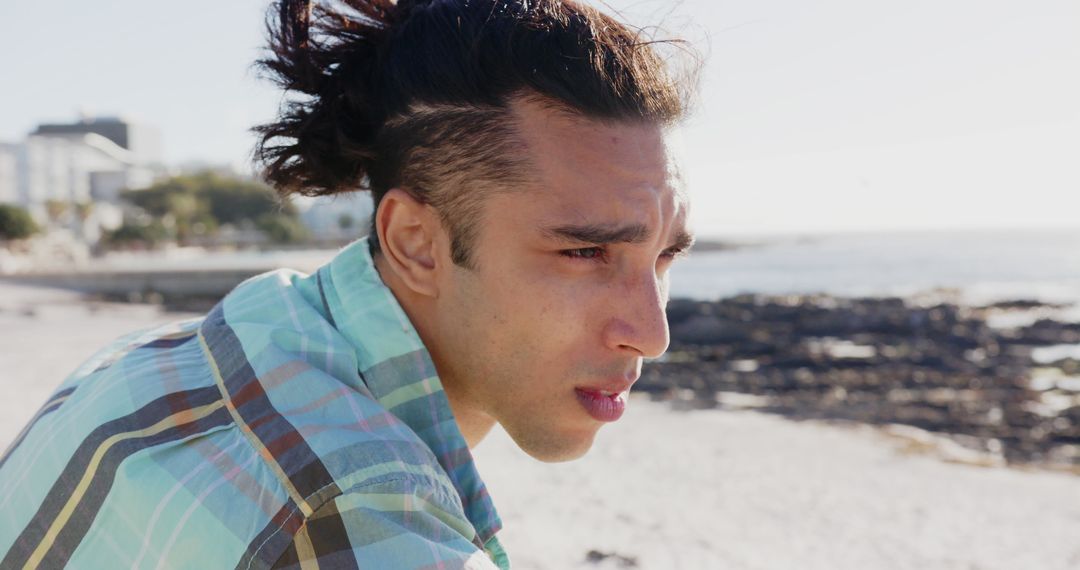 Contemplative Man with Under-Cut Hairstyle at Beach - Free Images, Stock Photos and Pictures on Pikwizard.com