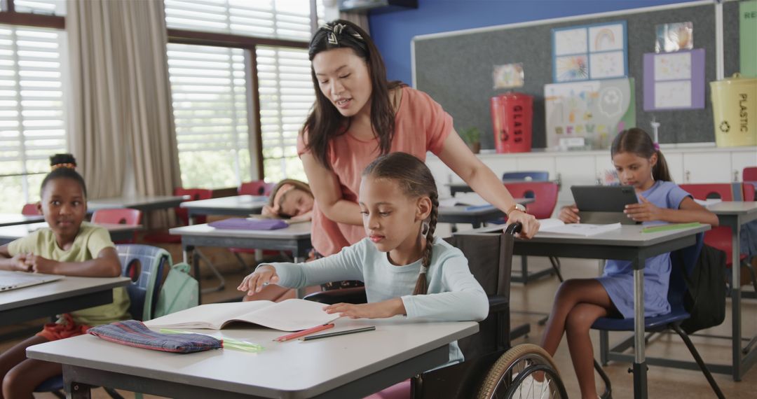 Teacher Assisting Young Student in Wheelchair in Diverse Classroom - Free Images, Stock Photos and Pictures on Pikwizard.com