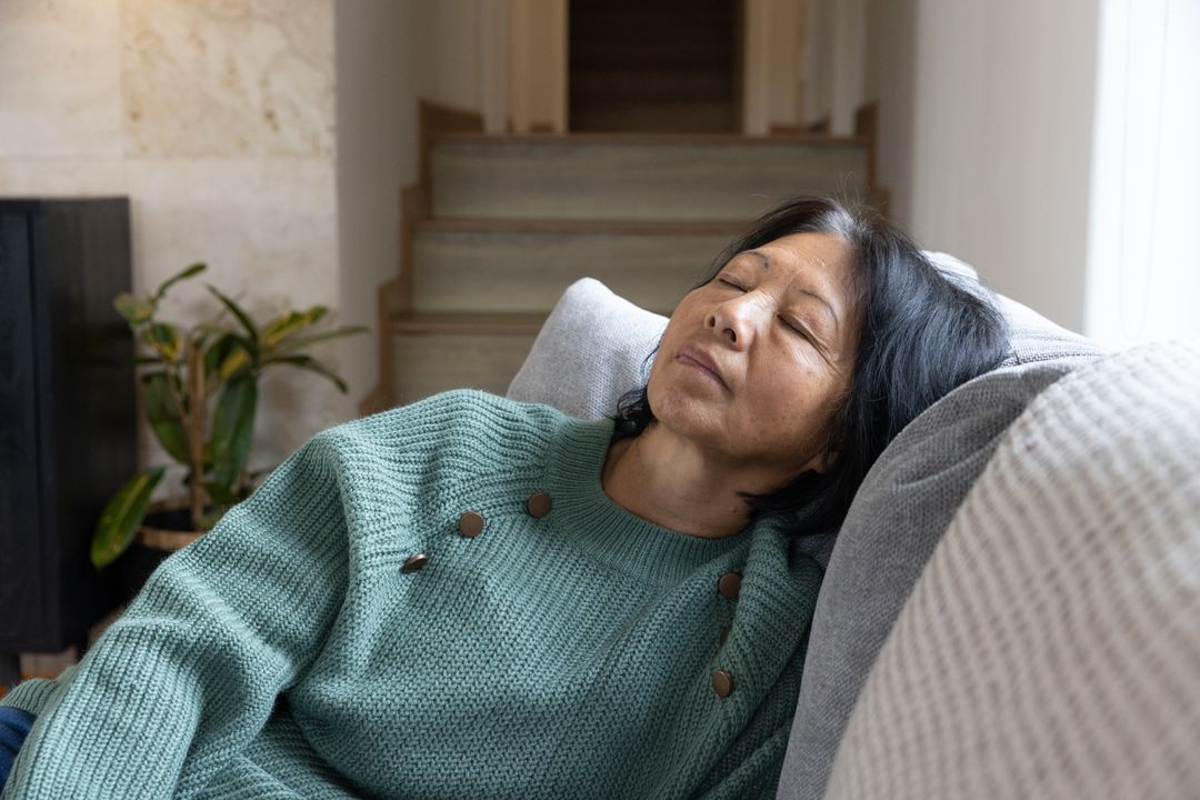 Senior Woman Relaxing on Comfortable Couch at Home