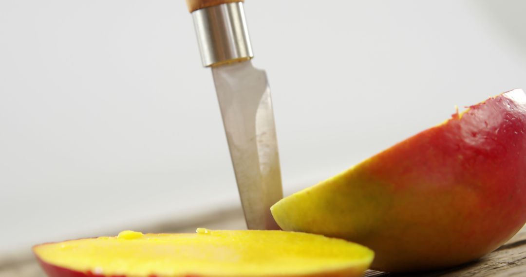 Knife Slicing Fresh Mango on Wooden Surface - Free Images, Stock Photos and Pictures on Pikwizard.com