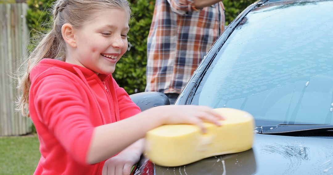 Young Girl Smiling and Washing Car with Sponge Outdoors - Free Images, Stock Photos and Pictures on Pikwizard.com