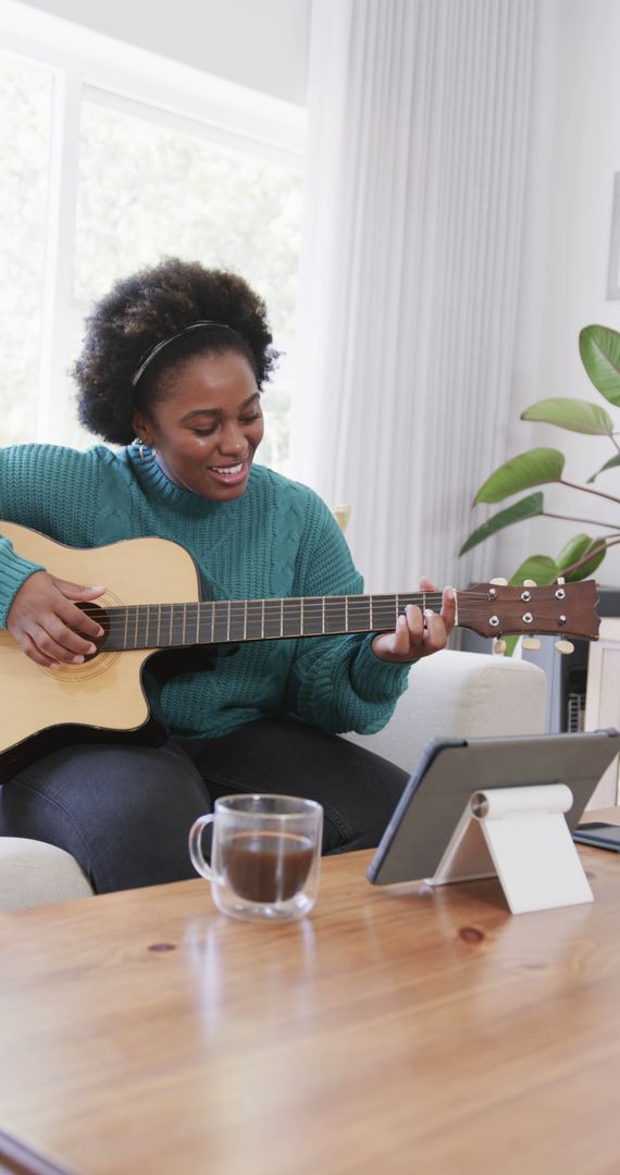 Young Woman Playing Acoustic Guitar and Smiling at Home - Free Images, Stock Photos and Pictures on Pikwizard.com