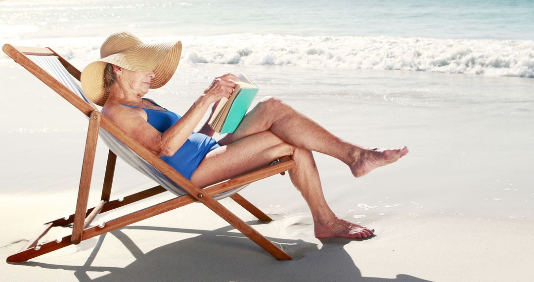 Senior Woman Relaxing on Beach Chair Reading Book by Seashore - Free Images, Stock Photos and Pictures on Pikwizard.com