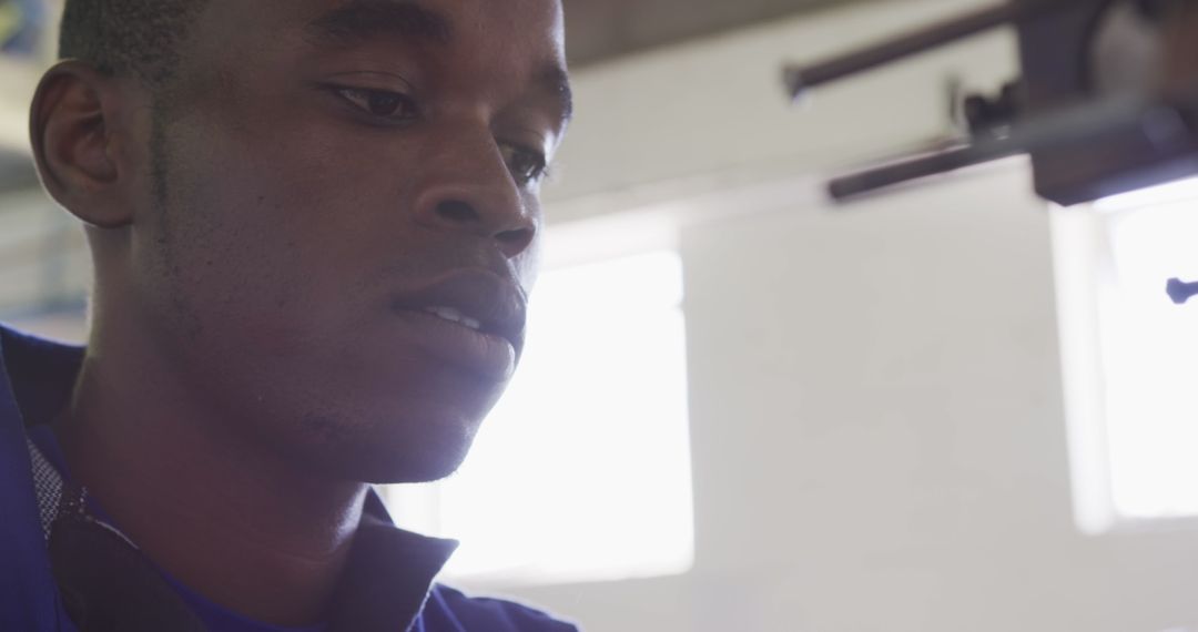 Focused Factory Worker Operating Machine in Cricket Ball Production