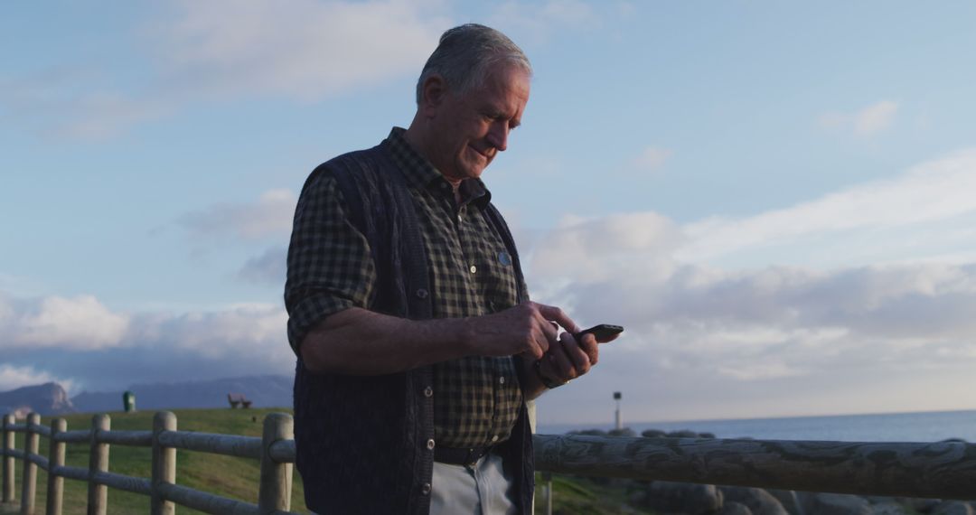 Senior Man Using Smartphone Outdoors at Sunset - Free Images, Stock Photos and Pictures on Pikwizard.com