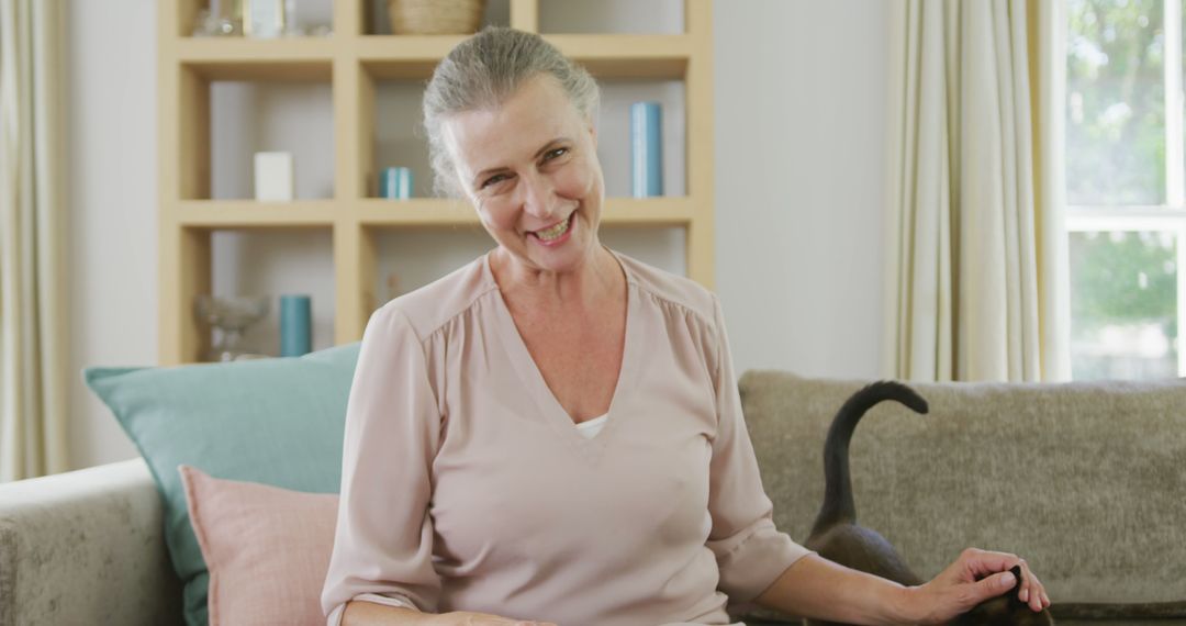 Smiling Senior Woman with Cat Relaxing On Sofa At Home - Free Images, Stock Photos and Pictures on Pikwizard.com