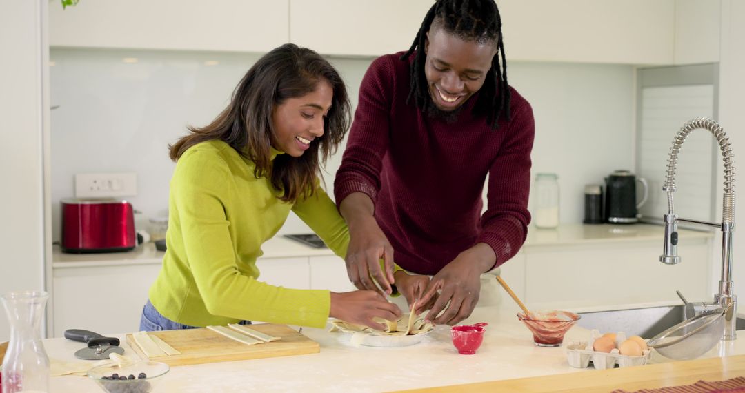 Couple Baking Pastry Together on Kitchen Island, Black Man and South Asian Woman Smiling