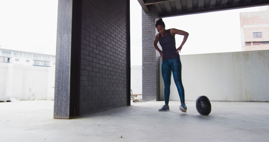 Woman Resting After Intense Workout, Standing by Medicine Ball in Urban Gym - Free Images, Stock Photos and Pictures on Pikwizard.com