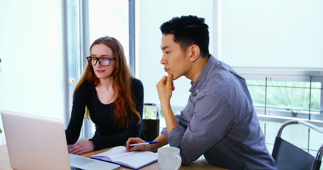 Diverse Business Professionals Analyzing Data on Laptop