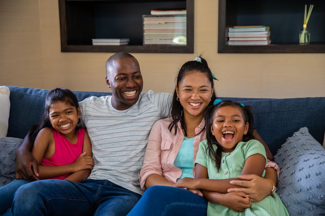Smiling Family Enjoying Relaxing Time Together on Sofa