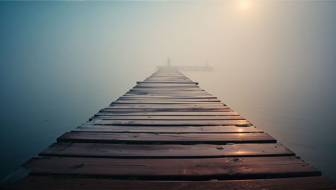Weathered Dock Extending into Tranquil Foggy Lake at Dawn